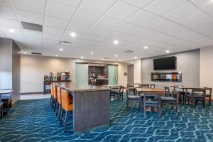 a dining room with tables and chairs and a tv at Best Western Plus Owensboro in Owensboro