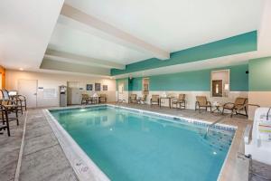 a pool with chairs and tables in a hotel room at Best Western Plus Owensboro in Owensboro