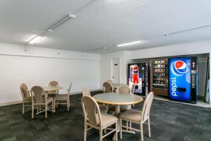 uma sala com mesas e cadeiras e uma máquina de refrigerantes em Motel 6-Butte, MT - Historic City Center em Butte