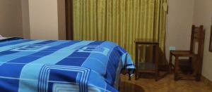 een slaapkamer met een blauw bed en een groen gordijn bij Villa hospedaje in Huaraz