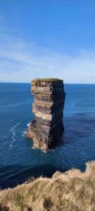 a rock pillar in the water in the ocean at Country Cabin in Mullagh