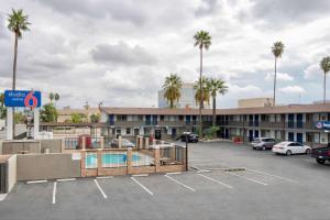 a parking lot with a pool and palm trees at Studio 6 Suites San Bernardino, CA in San Bernardino