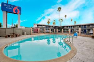 a swimming pool at a resort with a hotel at Studio 6 Suites San Bernardino, CA in San Bernardino