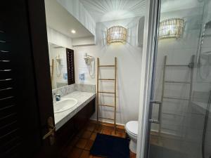 biała łazienka z umywalką i toaletą w obiekcie La Caravelle - Agréable studio vue sur mer avec piscine w mieście La Trinité