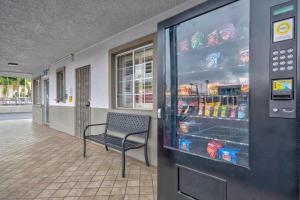 a bench in front of a refrigerator with drinks at Studio 6 Suites San Bernardino, CA in San Bernardino