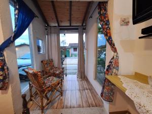 a room with two chairs and a table and a window at Chale Sol in Caraguatatuba
