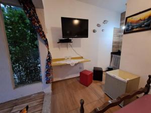 a living room with a flat screen tv on the wall at Chale Sol in Caraguatatuba