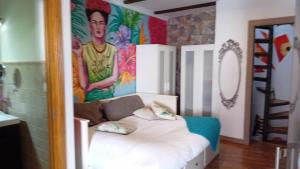 Ce lit se trouve dans un dortoir orné d'une peinture murale. dans l'établissement Frida Almuñecar, à Almuñécar