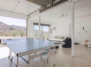 een tafeltennistafel in een kamer met een bank bij Highlands Retreat- Your Own Private Resort w Pool in Joshua Tree