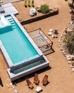 een uitzicht over een zwembad met ligstoelen bij Highlands Retreat- Your Own Private Resort w Pool in Joshua Tree