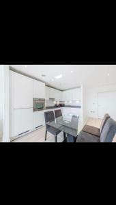 a living room with a glass table and chairs at Amazing Apartment in Harlow