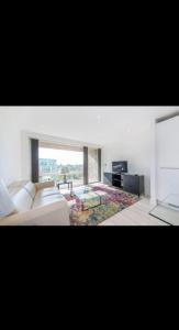 a living room with a white couch and a glass table at Amazing Apartment in Harlow