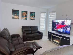 uma sala de estar com 2 cadeiras e uma televisão de ecrã plano em Voltage em Ottawa