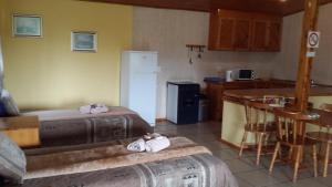 a small kitchen with a refrigerator and a table at The Old Mill Hotel in Machadodorp