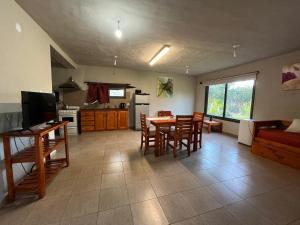 cocina y sala de estar con mesa y sillas en Cabaña La Huerta "Traslasierra" en Villa Dolores