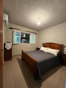 多洛雷斯鎮的住宿－Cabaña La Huerta "Traslasierra"，一间卧室设有一张床和一个窗口