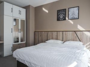 a bedroom with a large bed with a wooden headboard at GAVAS Modern Central Apartments in Cluj-Napoca