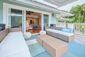 eine Terrasse mit Korbmöbeln auf einem Haus in der Unterkunft Rainbow Escape & Bungalow in Honolulu
