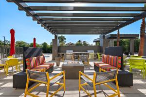 a patio with colorful chairs and a fire pit at Home2 Suites By Hilton San Bernardino in San Bernardino