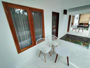 a room with three chairs and a table and a window at Kuta Garden in Kuta Lombok