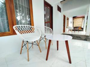 a pair of chairs and a table in a room at Kuta Garden in Kuta Lombok +31 photos