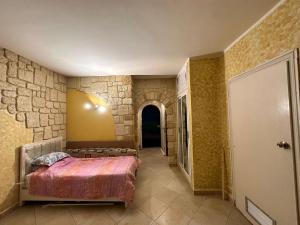 a bedroom with a bed in a stone wall at Studio s0 sousse kantaoui maison de la mer in Port El Kantaoui