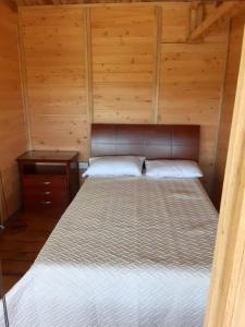 um quarto com uma cama num chalé de madeira em Cabaña Pavachoque em Puente Nacional
