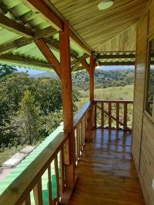 a wooden porch with a view of the mountains at Cabaña Pavachoque in Puente Nacional