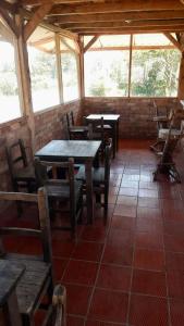 um restaurante com mesas e cadeiras de madeira e janelas em Cabaña Pavachoque em Puente Nacional
