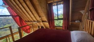a bedroom with a bed and a large window at Chalet de Liz in Guatapé