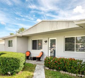 a white house with orange chairs in the front yard at Home with heated pool close to beach and FLL airport in Fort Lauderdale