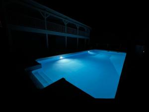a swimming pool lit up in the dark at Le Voilier - Élégant studio vue sur mer avec piscine in Les Trois-Îlets