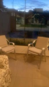 zwei Stühle vor einem Fenster in der Unterkunft Hermosa casa para vacacionar in Santa Cruz de la Sierra