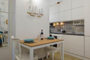 uma cozinha com uma mesa de madeira e armários brancos em [350 metri dal mare] Centrale A/C Wifi em Civitanova Marche