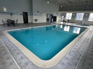 uma grande piscina com água azul num edifício em HomeTowne Studios by Red Roof Flint em Flint