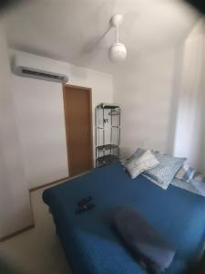 um quarto com uma cama azul num quarto em Apto 400 mt da orla em Salvador