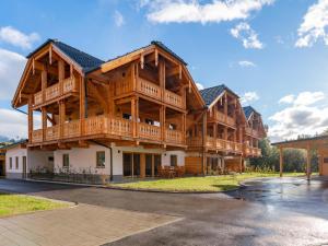 a large wooden house with a wrap around porch at AlmApARTment Mauterndorf Pichl 7-3 in Mauterndorf