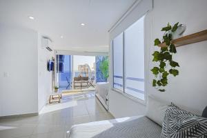 ein Wohnzimmer mit einem Sofa und einem Balkon in der Unterkunft Riviera Suite - Livin Colombia in Cartagena de Indias