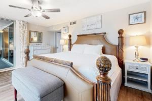 a bedroom with a bed and a chair and a ceiling fan at Shoreline Towers 3094 in Destin