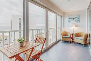 um quarto com uma mesa e cadeiras e janelas grandes em Shoreline Towers 3094 em Destin