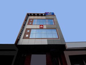 a tall building with blue windows on top of it at Collection O Red Paradise in Zirakpur