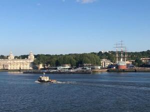 un pequeño barco en un gran cuerpo de agua en Double bedroom with bathroom en suite in London Docklands Canary Wharf E14 en Londres