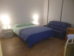 a bedroom with a bed and a blue couch at Cordoba y Florida, Cordoba 618 in Buenos Aires