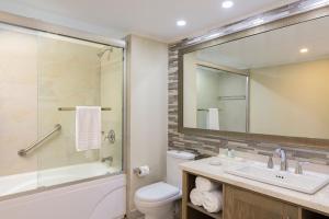 a bathroom with a sink and a toilet and a mirror at Turtle Beach by Elegant Hotels - All Inclusive in Christ Church