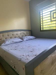 an empty bed in a bedroom with a window at Cagayan De Oro house in Cagayan de Oro
