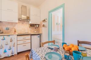 una cocina con una mesa con un tazón de naranjas. en Casa Zullo B4, en Capoliveri