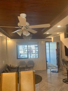 a ceiling fan in a living room with chairs at Cagayan De Oro house in Cagayan de Oro