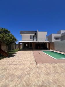 a house with a swimming pool in front of it at Casa Paraiso de Praia in Porto Seguro