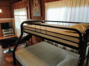 a bedroom with two bunk beds and a television at Cabañas del Mar in Tela