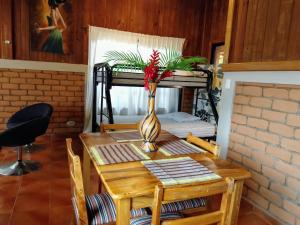 a dining room table with a vase on top of it at Cabañas del Mar in Tela